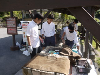 スメ（温泉蒸気釜）に食材を入れる様子